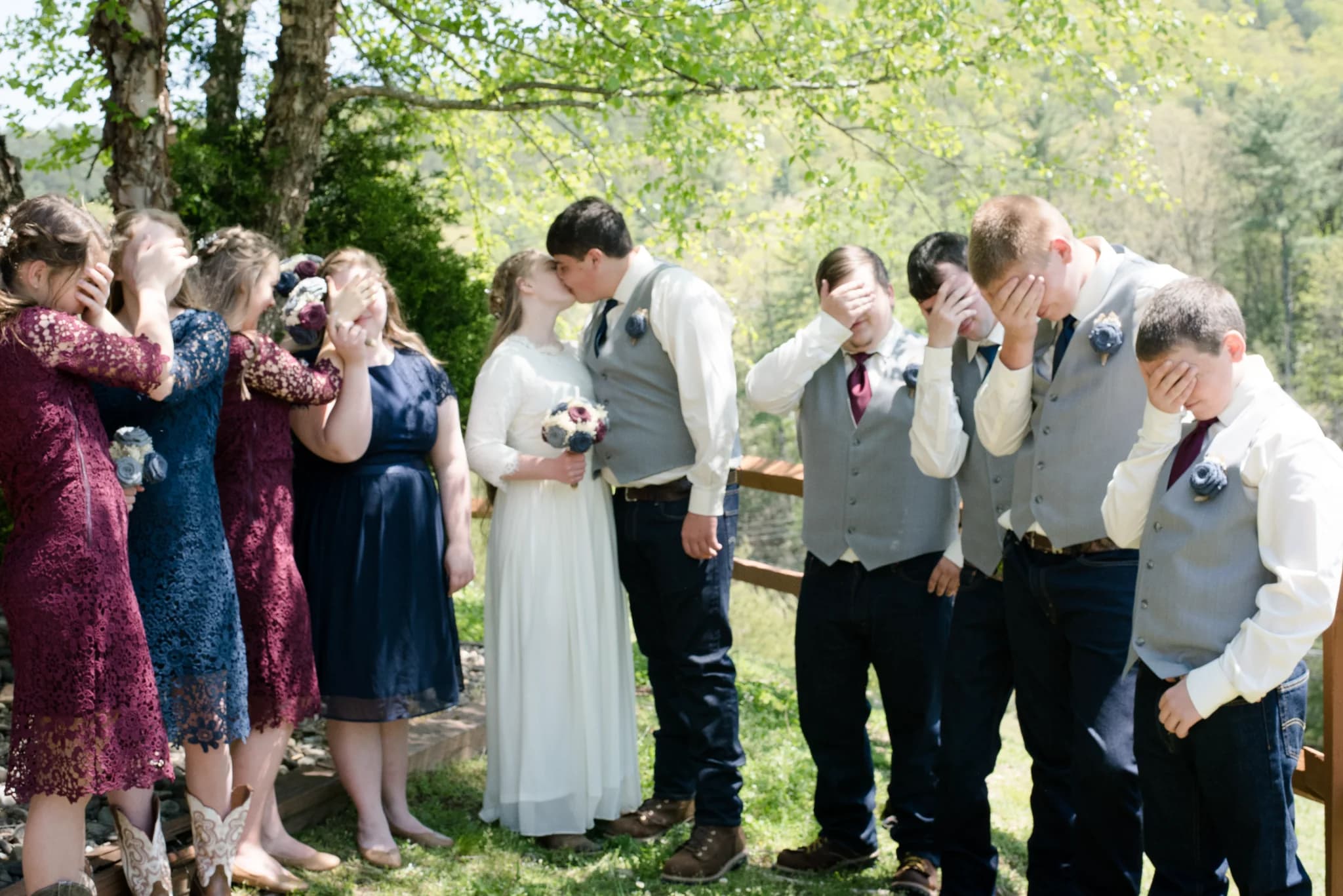 Bride and groom kissing with wedding party outdoors at Moose Hollow Lodge in Pigeon Forge near the Smoky Mountains