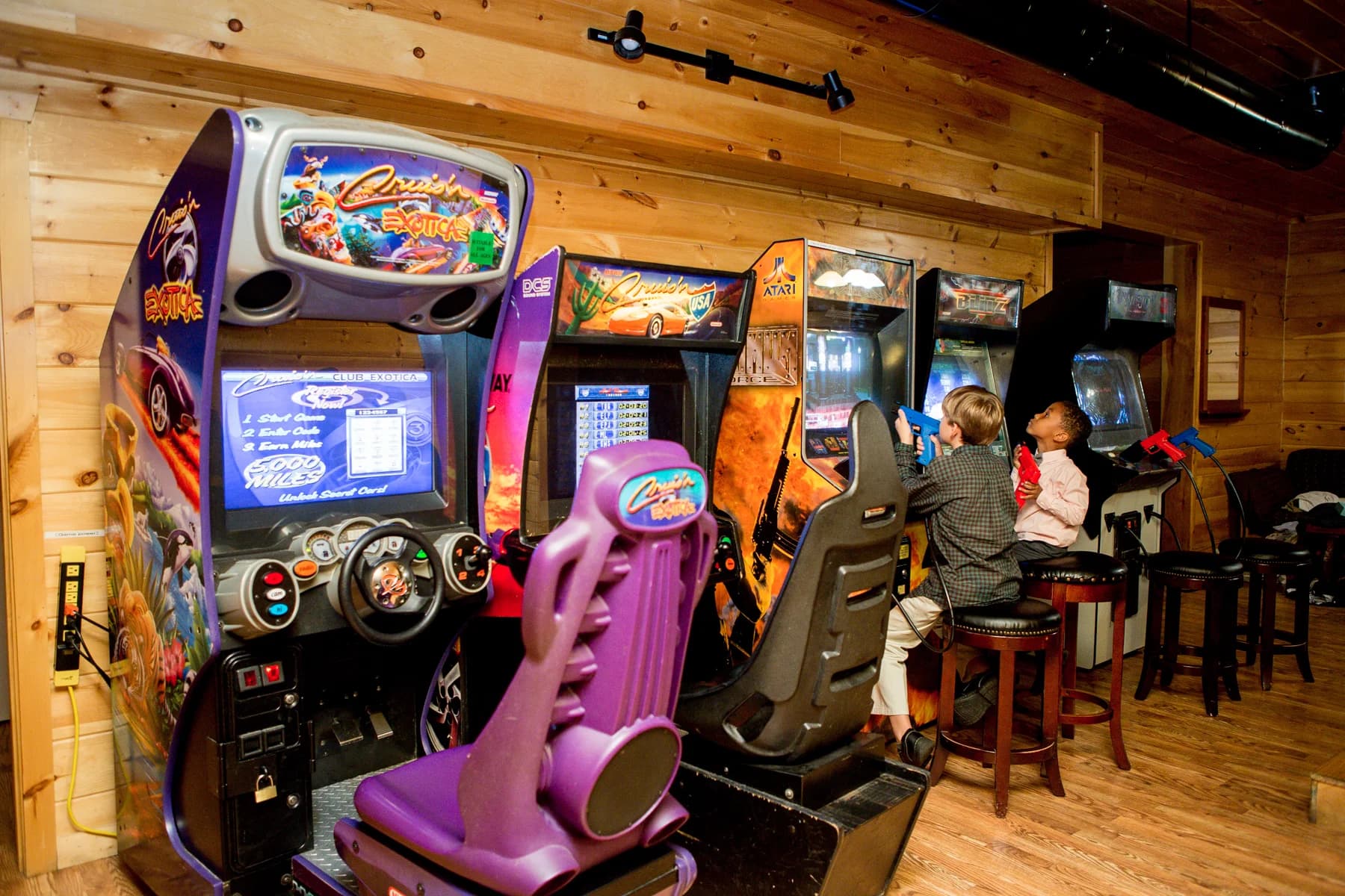 Rustic arcade game room with racing and shooting machines at Moose Hollow Lodge in Pigeon Forge