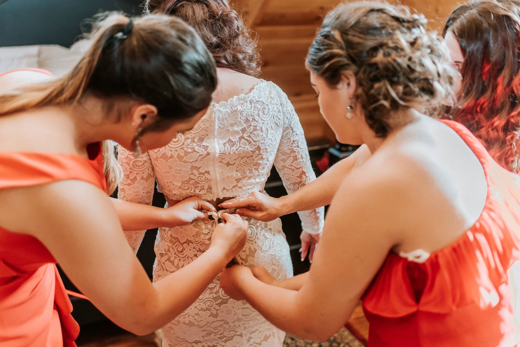 Bridesmaids helping bride get ready in a rustic bridal suite at Moose Hollow Lodge in Pigeon Forge