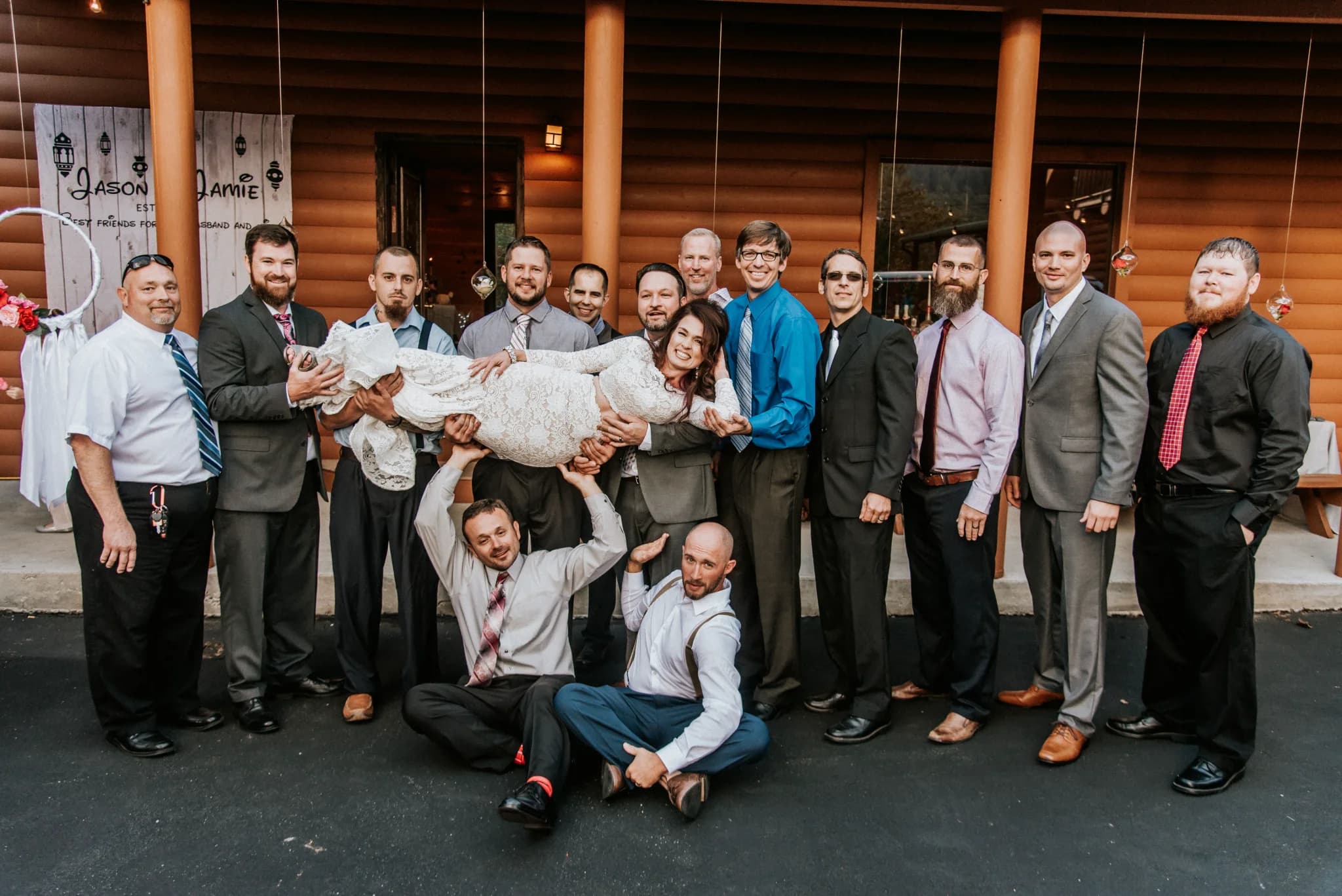 Groomsmen holding bride outside rustic log cabin at Moose Hollow Lodge in Pigeon Forge near Smoky Mountains