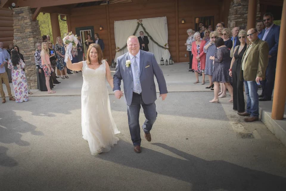 Bride and groom walk through guests at outdoor wedding ceremony near Dollywood at Moose Hollow Lodge in Pigeon Forge