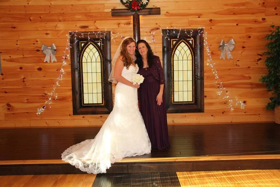 Bride in rustic wood wedding chapel with stained glass windows at Moose Hollow Lodge in Pigeon Forge.
