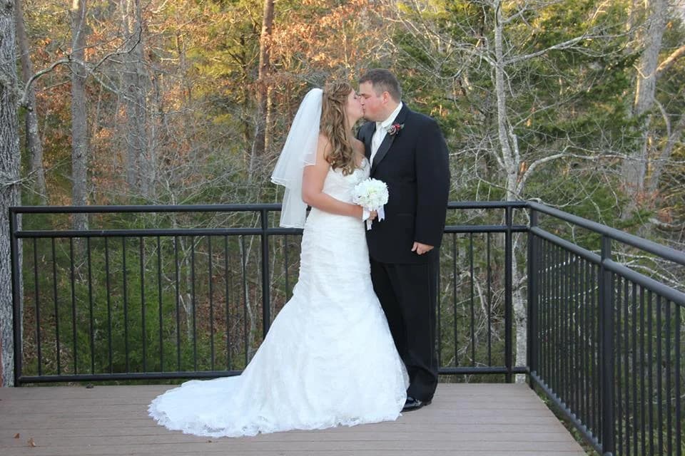Bride and groom kissing on deck with Smoky Mountains views near Dollywood at Moose Hollow Lodge in Pigeon Forge.