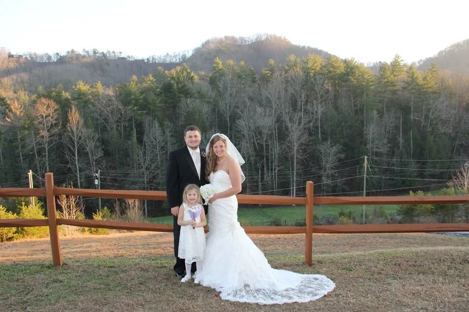 Wedding couple by wooden fence with Smoky Mountain views at Moose Hollow Lodge in Pigeon Forge near Dollywood