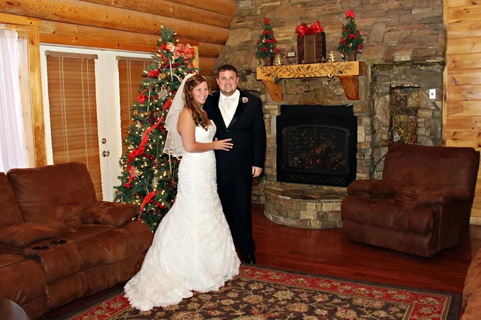 Wedding couple in rustic living room with stone fireplace at Moose Hollow Lodge in Pigeon Forge