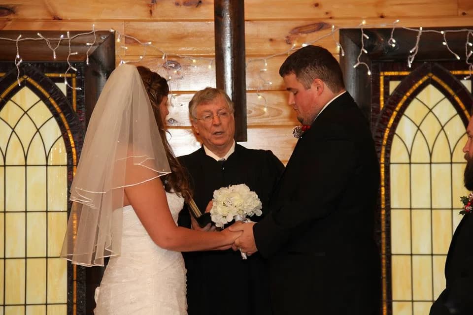 Wedding ceremony in rustic log chapel with stained glass windows at Moose Hollow Lodge in Pigeon Forge