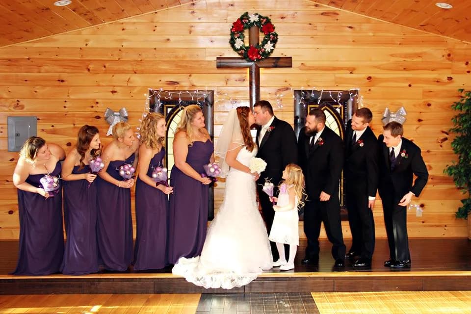 Rustic wood-paneled wedding chapel with a large cross and floral wreath at Moose Hollow Lodge in Pigeon Forge