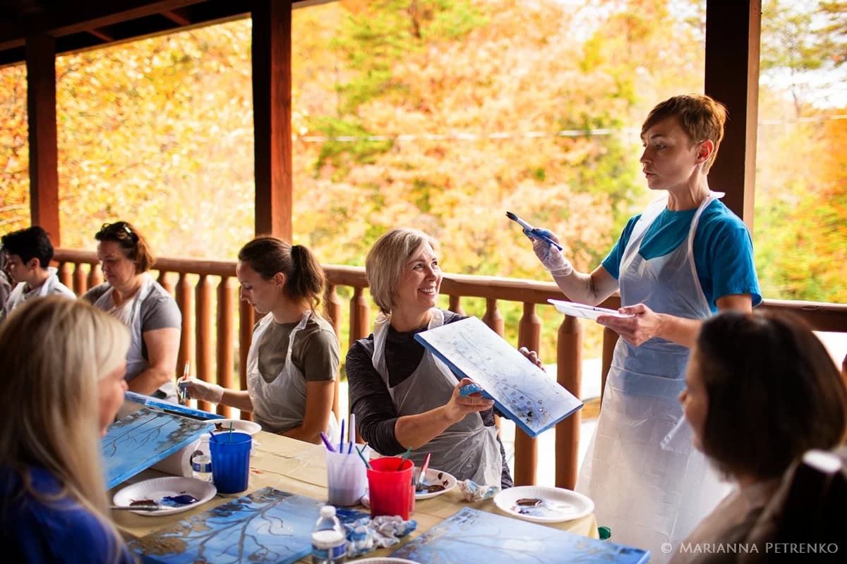 Group painting class on a covered deck with fall views at Moose Hollow Lodge in Pigeon Forge near Dollywood