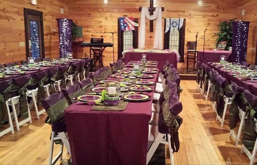 Rustic banquet hall with elegant table settings and wood-paneled walls at Moose Hollow Lodge in Pigeon Forge