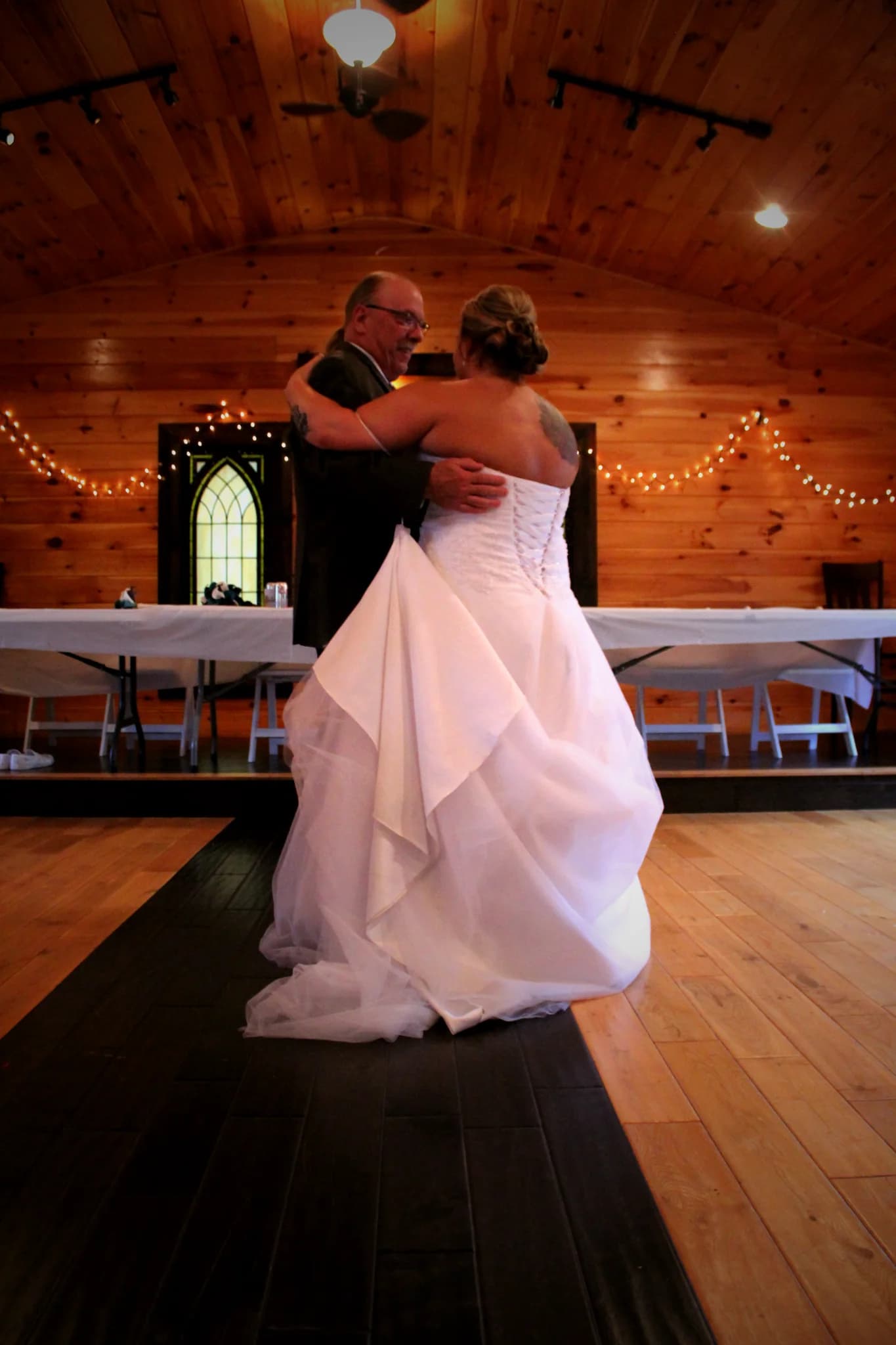 Wedding dance in rustic chapel with vaulted wood ceiling and string lights at Moose Hollow Lodge in Pigeon Forge.