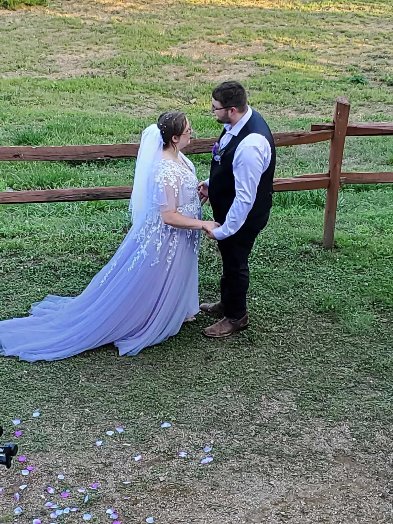 Bride in lavender dress and groom by rustic fence at Moose Hollow Lodge wedding venue in Pigeon Forge near Smoky Mountains