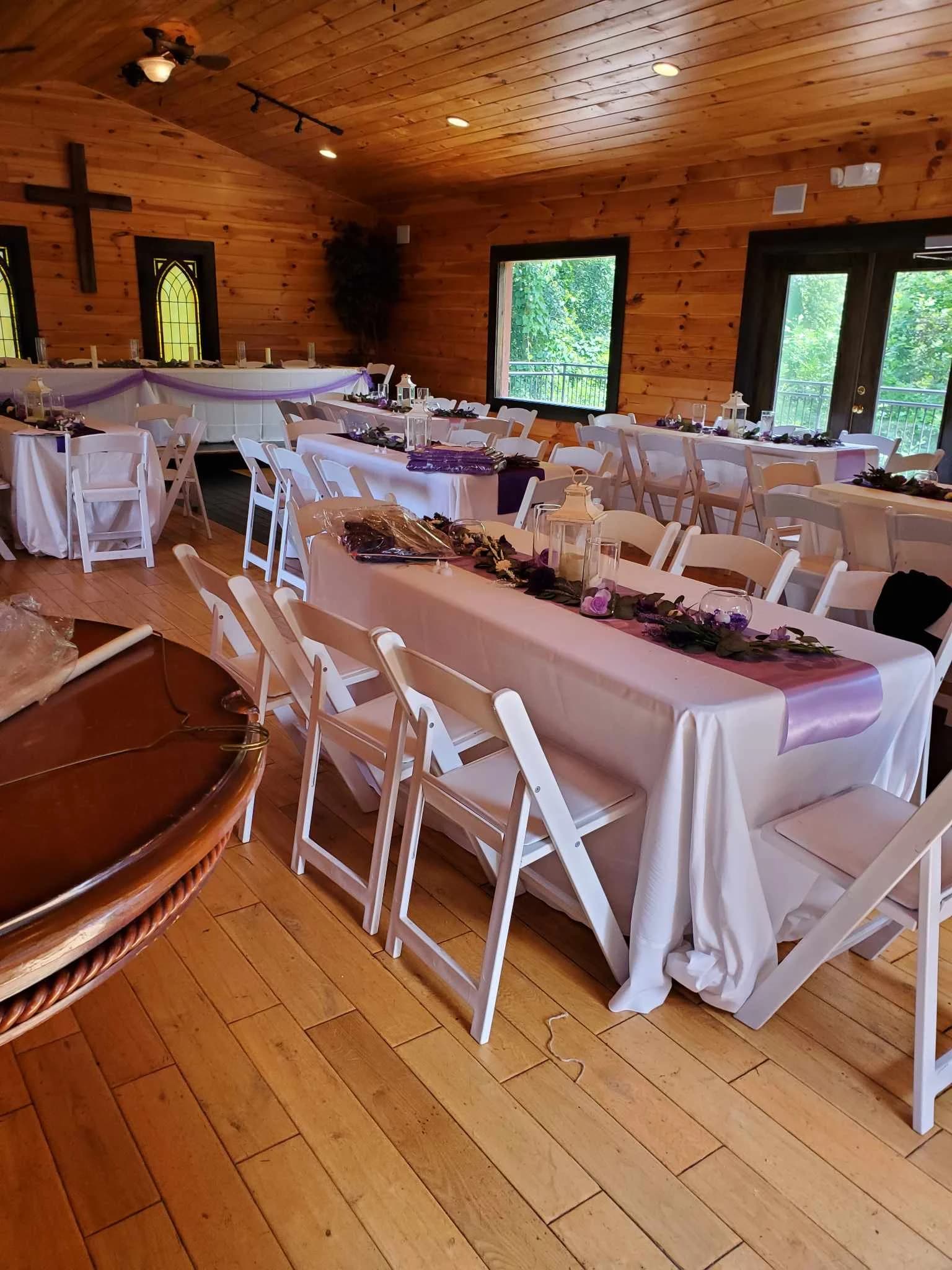 Rustic wedding reception hall with white linens and purple decor at Moose Hollow Lodge in Pigeon Forge