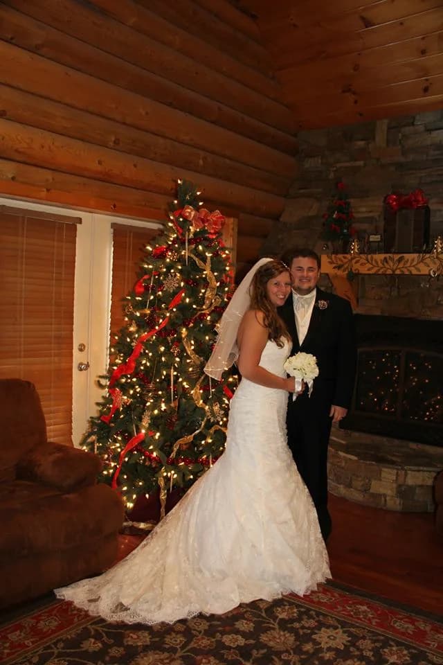 Bride and groom by Christmas tree and stone fireplace at Moose Hollow Lodge in Pigeon Forge