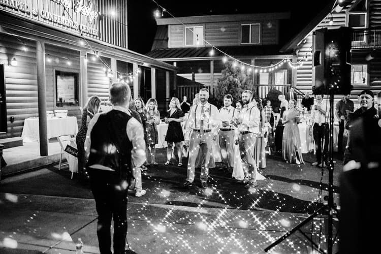 Guests at Moose Hollow Lodge Chapel & Conference Center, gathered outdoors at night under string lights with disco effect.