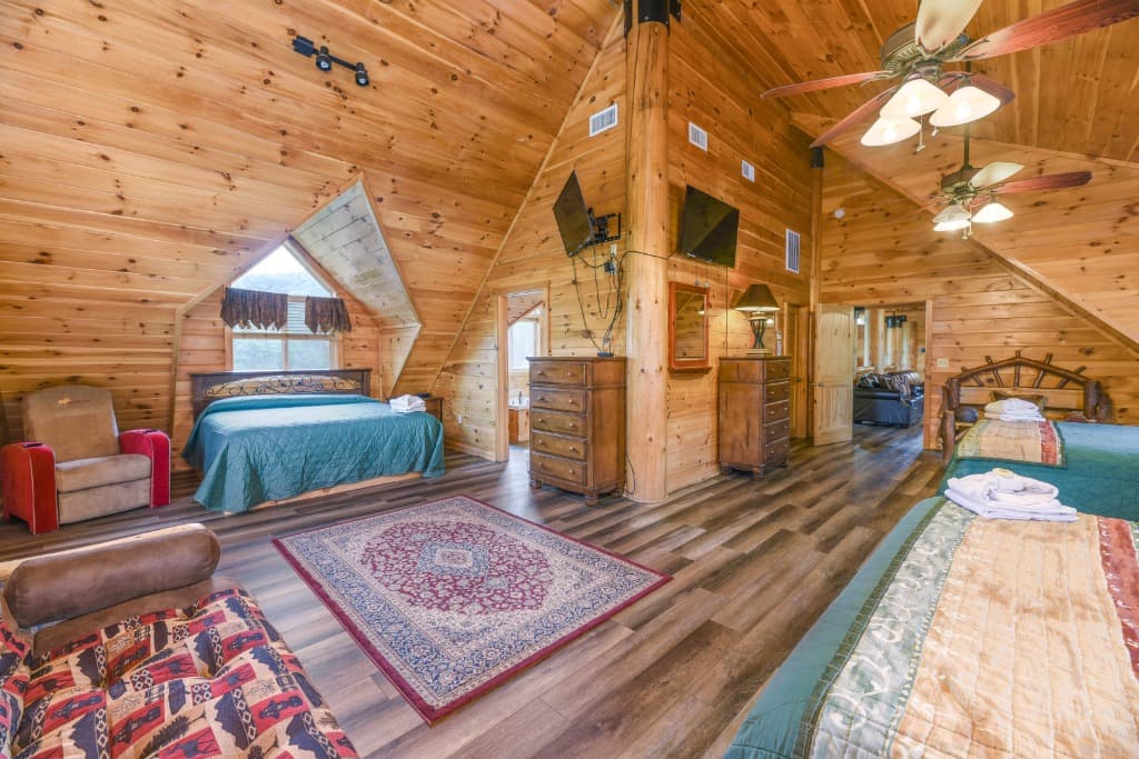 Spacious wood-paneled bedroom with vaulted ceilings and multiple beds at Moose Hollow Lodge in Sevierville
