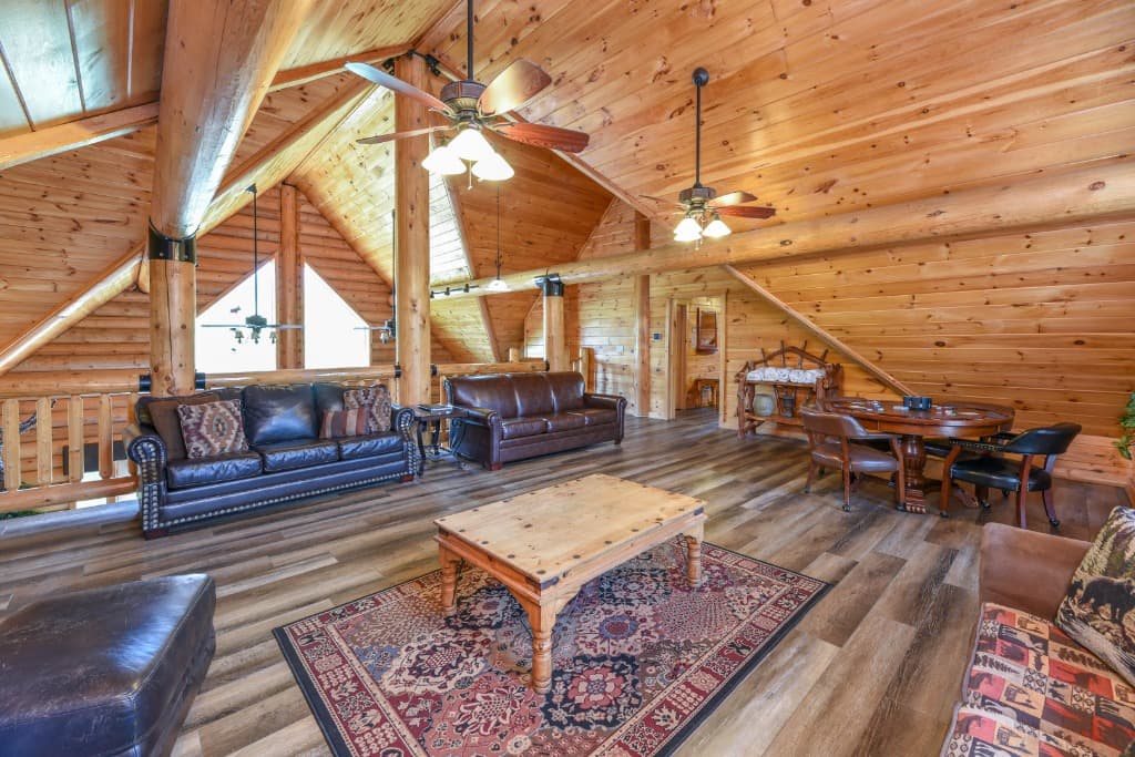 Spacious log cabin loft with leather sofas and game table at Moose Hollow Lodge in Sevierville