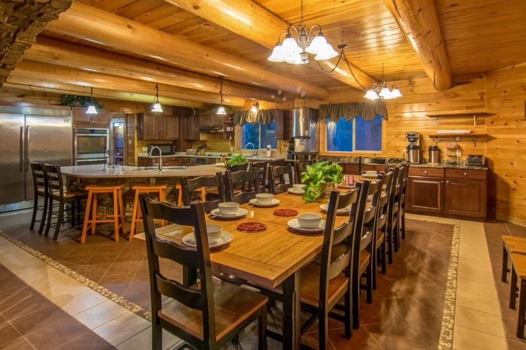 Log cabin dining room and kitchen with seating for large groups at Moose Hollow Lodge in Sevierville